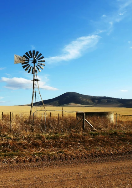 A windmill and water tank in a field