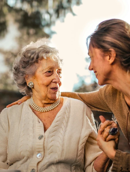 A lady looking after a senior in a garden