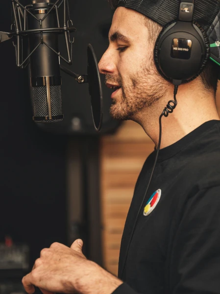 A man speaking into a microphone in a studio