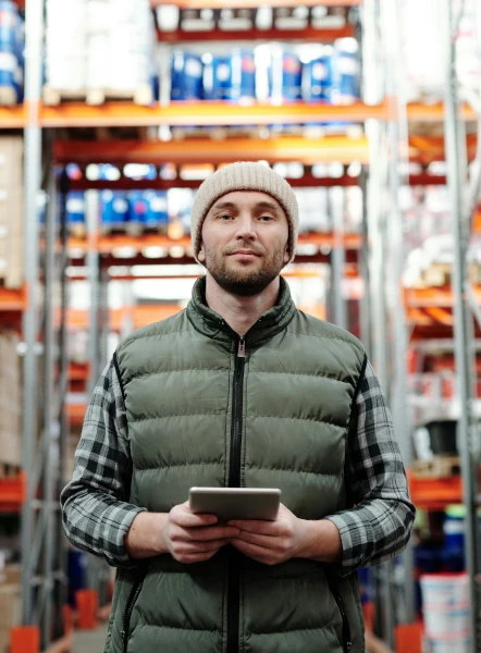 Man in a warehouse holding a tablet computer