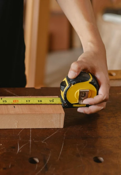 A man measuring a length of a plank